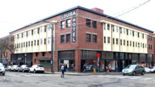 The exterior of brick building with sign that says "Louisa Hotel"