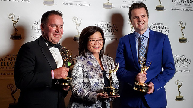Brian Callanan, Susan Han, and Christopher Barnes hold Emmy awards.