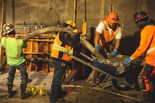 Construction workers pour concrete inside the West Seattle Bridge
