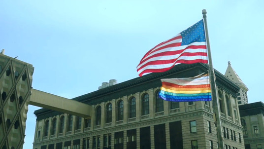 Pride flag flies next to American flag