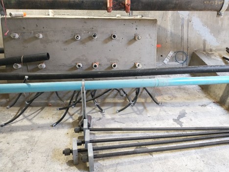 The bolts shown in the bottom of this photo will be inserted into the openings in the concrete anchor block. 