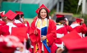 A class of 2022 Cleveland High School graduate smiles at the commencement ceremony. 