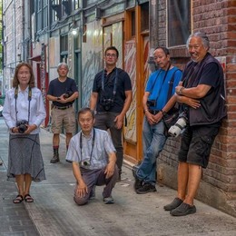 A group of photographers with cameras standing in an alley of Chinatown International District