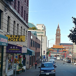 A view of street in Seattle's Chinatown International District with the Smith Tower in the background.