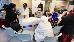 SHA residents sitting at a table with interpreters at a SHA transit pass distribution event