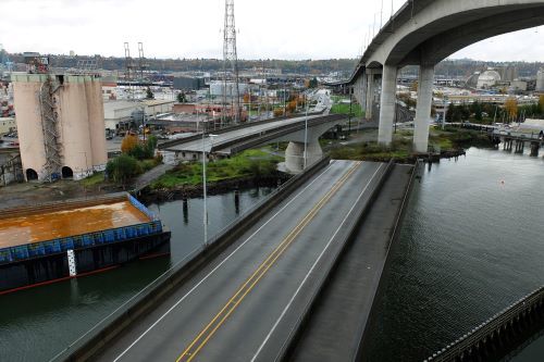 A photo of the Spokane St Swing Bridge swinging open for maritime vessels to travel through below.