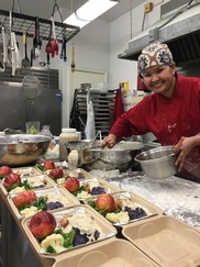 Chef at South Park Senior Center smiles in the kitchen as she prepares nutritious meals for delivery