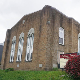 Exterior of Tolliver Temple, a brick building with tall arched windows.