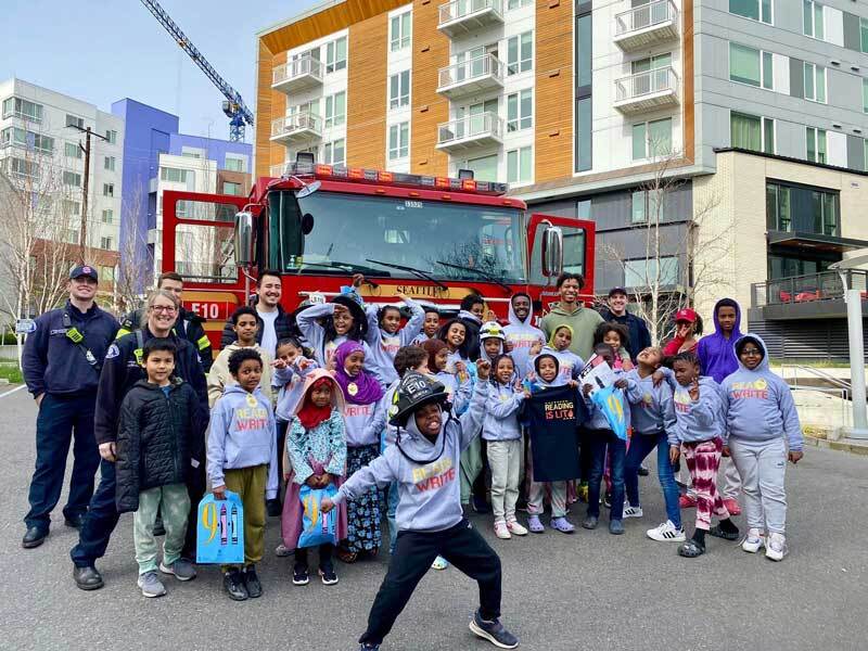 Group photo of firefighters from Engine 10 and children at Yesler Terrace