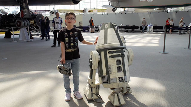 A young boy with his R2D2 robot. 