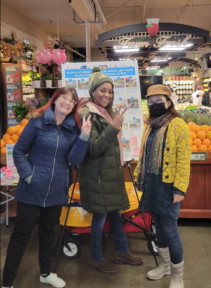 Three people gathering community input in the Othello neighborhood at a grocery store.