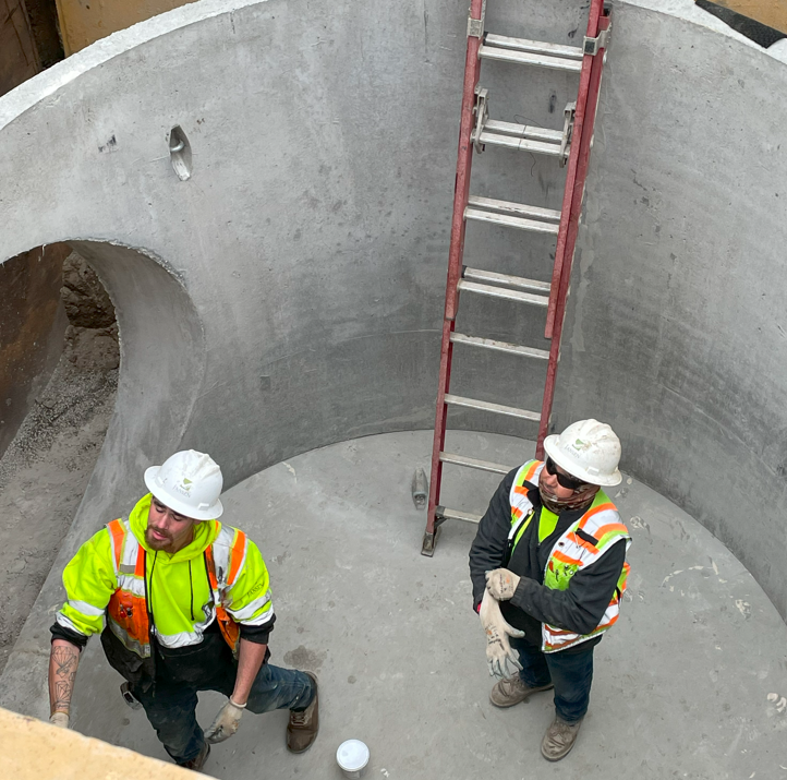 An image of two construction workers standing in the new stormwater tank at 10th Ave.