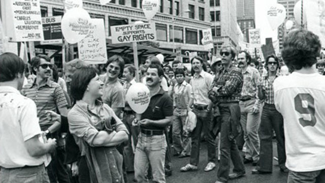 Black and white image of large crowd carrying signs in street