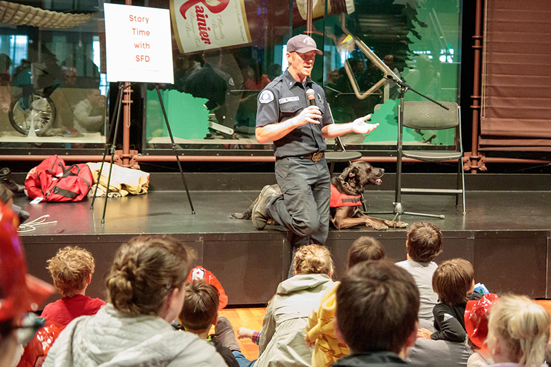 Children gather for firefighter story time with SFD during Fire Day at MOHAI