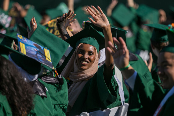 A Franklin High School graduate waves at the camera at the class of 2023 commencement ceremony. 