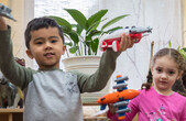 Seattle Preschool Program children play with toy airplanes. 