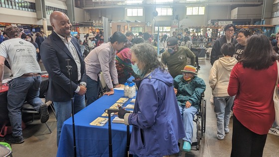 Director Betts and Troy Chen of the OPA talking to community members at AAPI Month Event at the Seattle Center