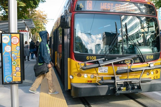 A rider boards King County Metro’s RapidRide C bus to West Seattle.