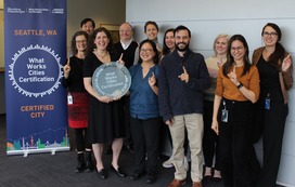 City of Seattle staff pose for a photo, holding a What Works City award