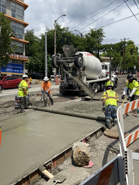 Construction crews pour and grade concrete