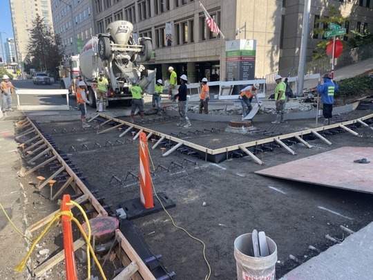 Construction crews rebuild the roadway surface in downtown