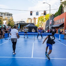 Four individuals playing a pickleball match