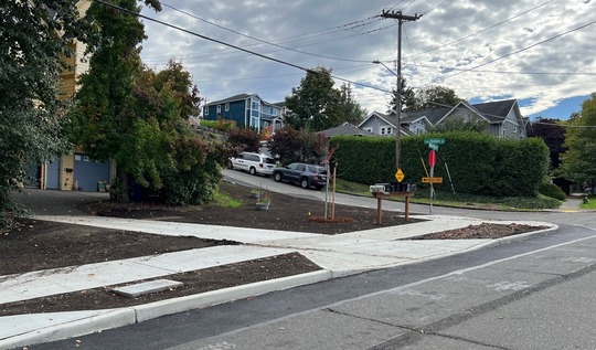 New sidewalk, curb, topsoil, and driveway on the eastside of Highland Park Way SW 