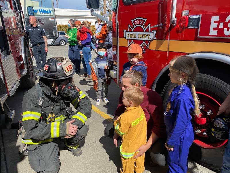 Firefighter greeting a young family at a fire safety fair