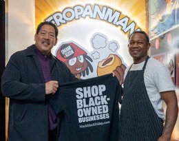 Mayor Harrell and a business owner hold up a shirt that reads "Shop Black-owned businesses"