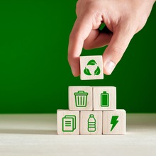 hand stacking blocks with green images