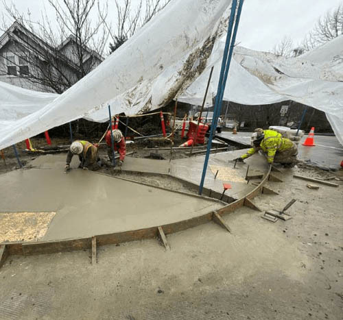 Construction crew working in the rain to install new curb ramps