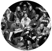A black and white photo of a group of performers posing together on stage.