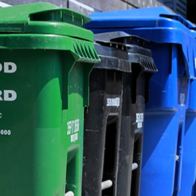 A close-up of different color waste bins