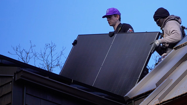 Technicians install solar panels