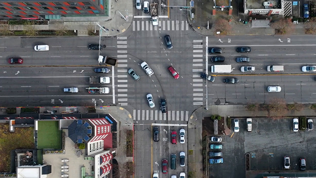 Aerial view of intersection with cars driving through