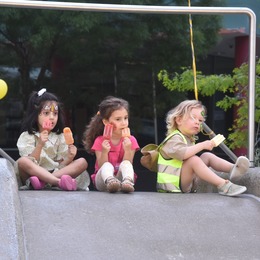 three kids sitting on play structure
