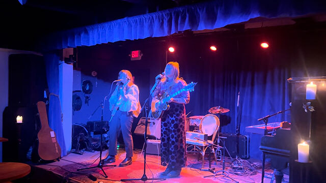 Band plays onstage with blue lighting