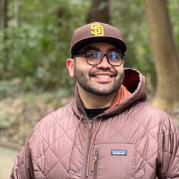 Photo of Gabriel Manriquez wearing a San Diego Padres hat and Patagonia jacket outside.