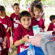 Kids standing in line at the park to collect their summer meals from HSD's Summer Food Service Program