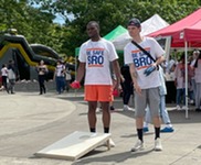 2 people play corn toss at Bsafe community event