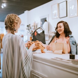 woman rings up customer at a counter