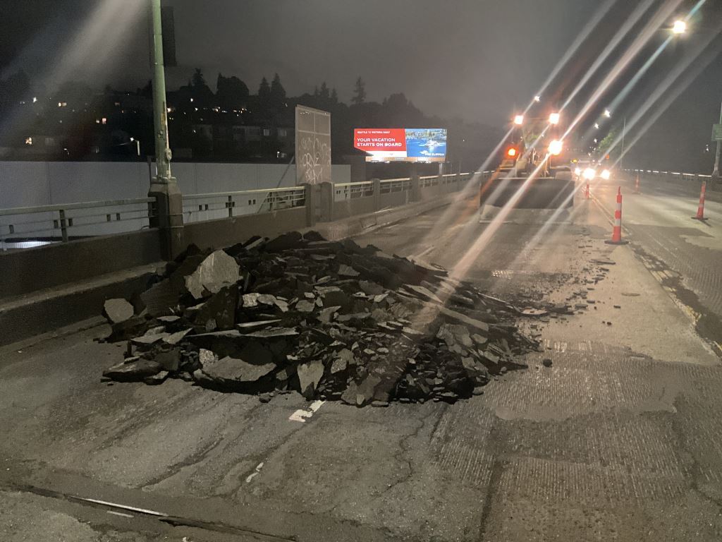 A photo of a front-end loader and a pile of asphalt taken during overnight work on the Ballard Bridge.