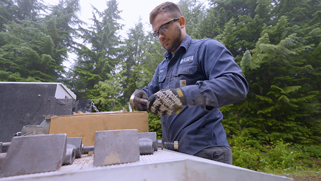 A mechanic works on a truck at Tolt Lake