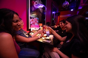 A group of girls with drinks saying cheers