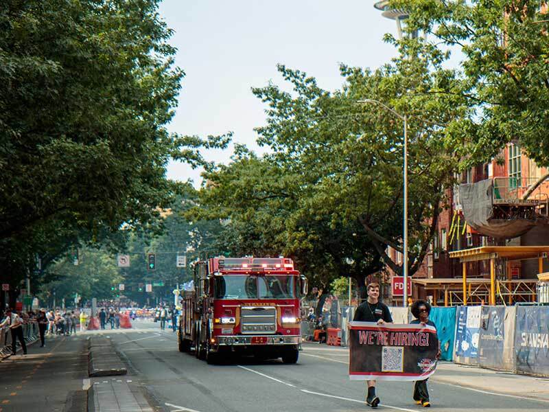 Seattle Fire personnel and Ladder 4 from Station 2 in Belltown march down the parade route at the Torchlight Parade.