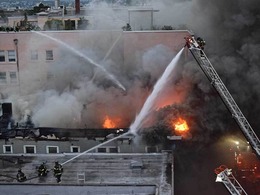 Firefighters put water on a rooftop fire in a three-story vacant apartment building in Capitol Hill