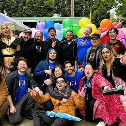 A group of Entre Hermanos volunteers gathered in a rainbow of colors to celebrate Pride