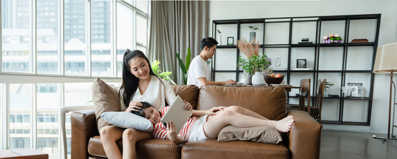 asian family of three relaxing in their living room.