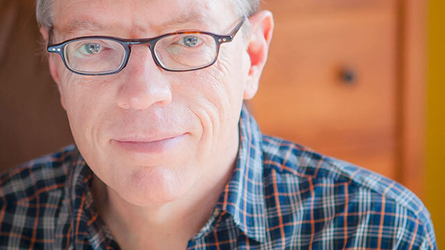 Close up of man with glasses and blue plaid shirt