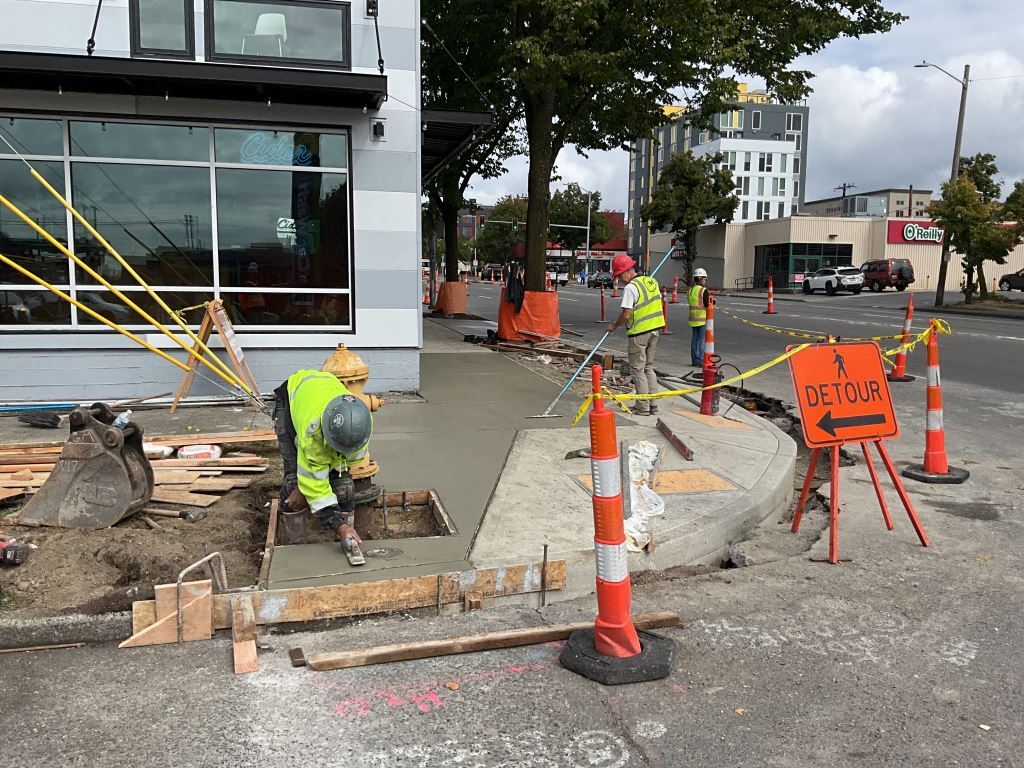 Construction crews lay new pavement at the corner of 15th Ave NW and NW 52nd St.